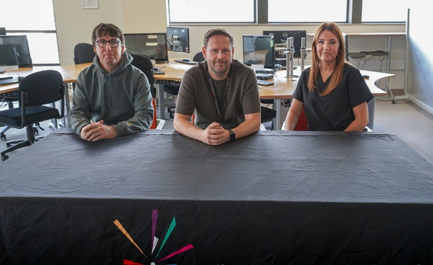 Three members of Hartlepool College's Parent Voice Forum seated at a meeting table in a College learning environment. Gary Riches, Deputy Principal and Chief Executive, sits between parent representatives Lee Connor and Laura Watts during the group's first face-to-face meeting.